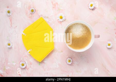 Atemschutzmaske KN95 oder FFP2 und Tasse Kaffee Stockfoto