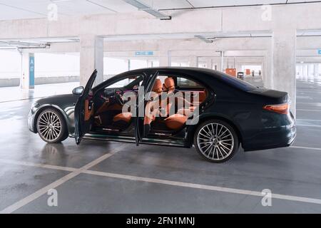 Luxuriöse Mercedes S-Klasse mit offenen Türen, stehend auf einer Tiefgarage. Sichtbare komfortable Innenausstattung mit Leder und Holz. Katow Stockfoto