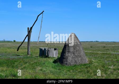 Österreich, alter Brunnen und Jurte aus Stroh im Nationalpark Neusiedlersee-Seewinkel, Teil der eurasischen Steppe im Burgenland und Teil der internationalen Stockfoto