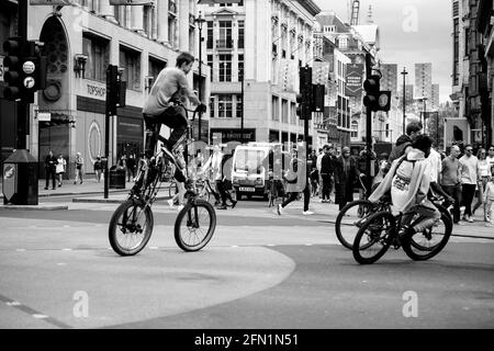 London, England, Großbritannien - 9. Mai 2021: Radfahrer fahren mitten im Verkehr auf der Oxford Street, Oxford Circus Credit: Loredana Sangiuliano / Alamy Live News Stockfoto