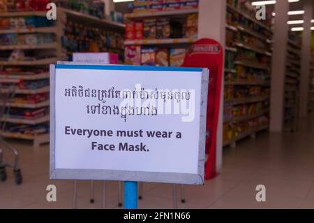 Während eines Ausbruchs von COVID - 19 zeigt ein Supermarkt während der Coronavirus-Pandemie ein zweisprachiges Schild „jeder muss eine Gesichtsmaske tragen“. Phnom Penh, Kambodscha. März 2020. © Kraig Lieb Stockfoto