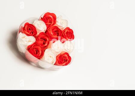 Dekorative Seife in Form von Rosen weiß und rot in der Herzkiste auf weißem Grund. Für Text platzieren. Valentinstag-Konzept Stockfoto