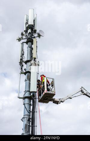 Ardara, County Donegal, Irland. Mai 2021. Telekommunikationsingenieure, die für Secto arbeiten, installieren Geräte auf einem Mast. Secto arbeitet derzeit mit Irlands führenden Telekommunikationsunternehmen zusammen, die umfangreiche FTTH-Netzwerke (Fiber to the Home Broadband) im ländlichen Irland bereitstellen. Stockfoto