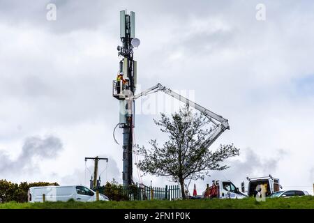 Ardara, County Donegal, Irland. Mai 2021. Telekommunikationsingenieure, die für Secto arbeiten, installieren Geräte auf einem Mast. Secto arbeitet derzeit mit Irlands führenden Telekommunikationsunternehmen zusammen, die umfangreiche FTTH-Netzwerke (Fiber to the Home Broadband) im ländlichen Irland bereitstellen. Stockfoto