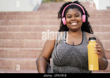 Sport junge afrikanische Frau Musik mit Kopfhörern hören - Fokus Auf dem Gesicht Stockfoto