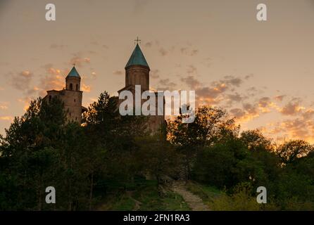 Dramatischer Himmel bei Sonnenuntergang über der Kirche der Erzengel in Gremi in Kacheti, Georgia. Stockfoto