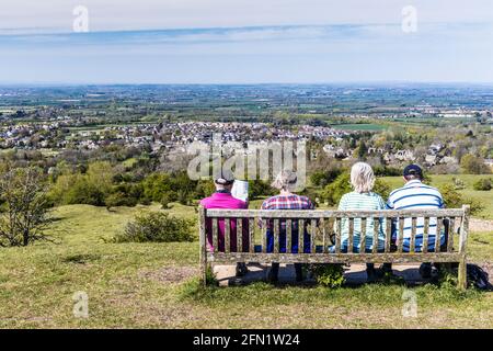 Vier Spaziergänger genießen den Blick über die Stadt Broadway in Worcestershire und das Valle of Evesham vom Cotswold Way-Fernwanderweg aus. Stockfoto