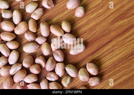 Erdnüsse (Erdnüsse) Affe Nüsse Samen auf Holz, gesunde Ernährung Hintergrund, selektive Fokus mit Unschärfe. Stockfoto