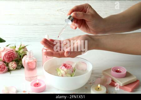 Weibliche Hände halten die Pipette mit ätherischem Rosenöl aus nächster Nähe Stockfoto