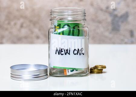 Zusammensetzung mit Spargeld Banknoten in einem Glas mit SMS an neues Fahrzeug Stockfoto