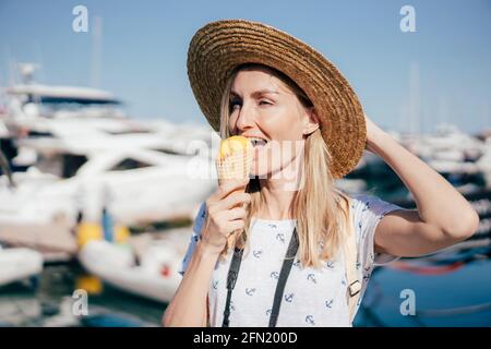 Junge fröhliche kaukasische Frau, die an einem Sommertag Sorbet-Eis isst. Stockfoto