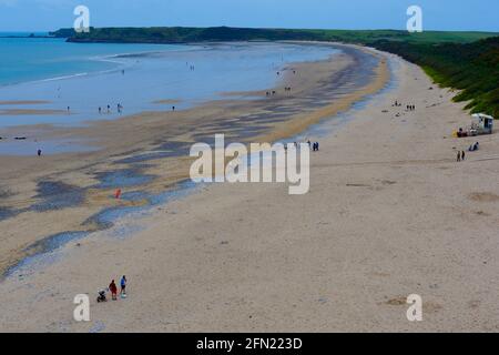 Blick auf South Beach Tenby von der Klippe aus. Bei Ebbe wurden große Bereiche mit weichem Sand freigelegt, während Urlauber entlang schlendern. Stockfoto