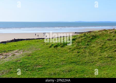 Eine wunderschöne Aussicht über die gemeinsame in Rest Bay, Porthcawl. Menschen genießen es, auf dem exponierten Sandstrand in der niedrigen zu laufen Stockfoto