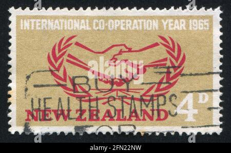 NEUSEELAND - UM 1965: Stempel gedruckt von Neuseeland, zeigt das Emblem des Internationalen Kooperationsjahres, um 1965 Stockfoto