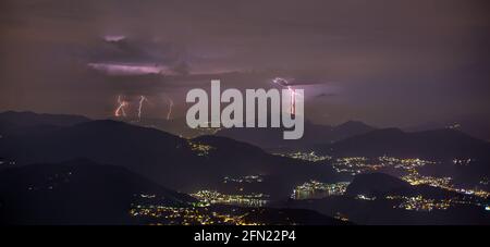 Gewitter mit mehreren Blitzeinschlägen über den Luganersee Stockfoto