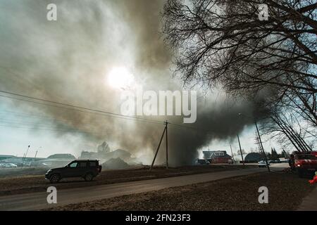 Das Feuer zerstört das Gebäude. Die Feuerwehr gießt Wasser auf das brennende Haus. Menschen ersticken durch den Rauch und Smog des Feuers. Feuer Stockfoto