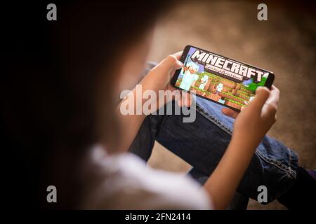 Bukarest, RUMÄNIEN - 10. Mai 2021: Illustrative redaktionelle Konzeptbild eines Kindes, das Minecraft-Spiel auf einem Mobiltelefon spielt. Stockfoto