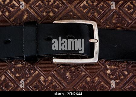 Nahaufnahme eines alten Gürtels mit Schnalle auf der Lederoberfläche Stockfoto
