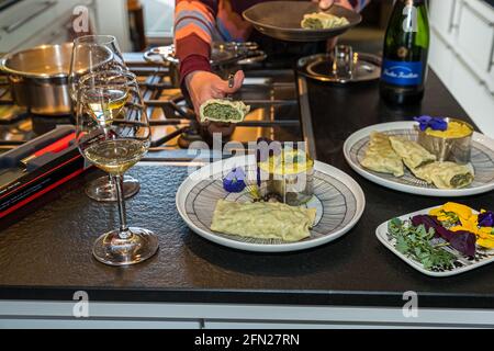 Maultaschen werden mit Zwiebelschmelze und Kartoffelsalat serviert. Oxalis-Blätter, Stiefmütterchen und violette Blüten vom Keltenhof sorgen für Farbe auf dem Teller Stockfoto