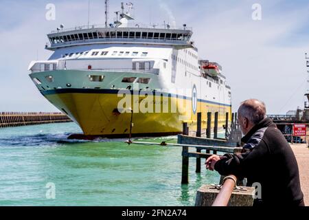 Ein Mann beobachtet die Transmanche Newhaven - Dieppe Ferry bei der Ankunft im Hafen von Newhaven, East Sussex, Großbritannien. Stockfoto