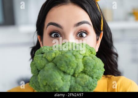 Brünette Frau Blick auf die Kamera in der Nähe reifen Brokkoli Stockfoto