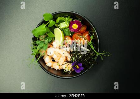 Sack Salat mit Garnelen in einer Schüssel. Zutaten Garnelen, blanchierten Spinat, Kirschtomaten, Reis, Gurke, soja-Ingwer-Sauce, würzige Sauce, Nori, Sesam Stockfoto