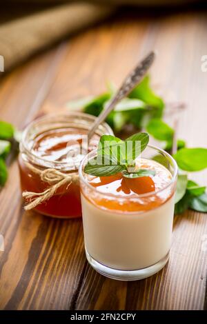 Hausgemachter Joghurt in einem Glas und mit Marmelade auf einem Holztisch Stockfoto