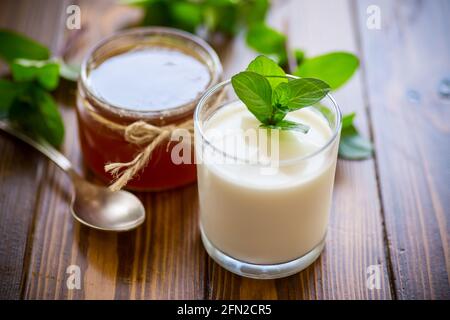 Hausgemachter Joghurt in einem Glas und mit Marmelade auf einem Holztisch Stockfoto