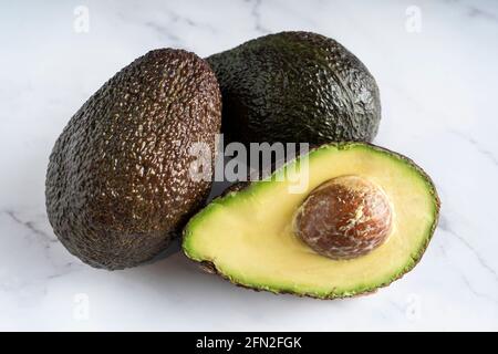 Avocado isoliert auf weißem Marmor Hintergrund Stockfoto