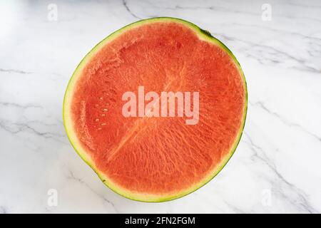 Halb Wassermelone isoliert auf weißem Marmor Hintergrund Stockfoto