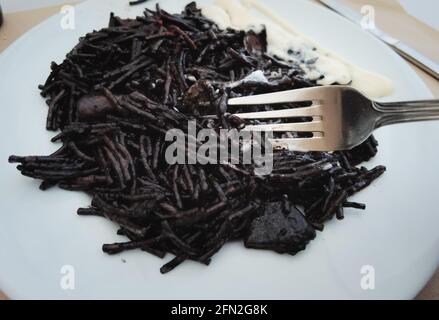 Schwarze Fideua oder schwarze Nudeln, traditionelles spanisches Seemannsgericht Stockfoto