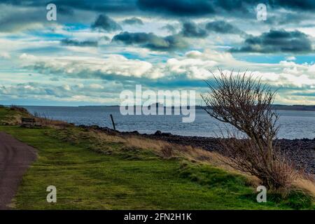 Bamburgh Castle von rund um den Hafen auf Holy Island, Northumberland, aus gesehen. Stockfoto
