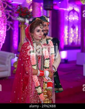 Wunderschöne atemberaubende indische Braut und Bräutigam tragen traditionell Kleid posieren auf ihrer Hochzeitszeremonie. Stockfoto