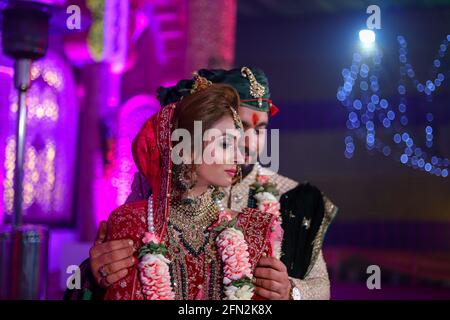 Wunderschöne atemberaubende indische Braut und Bräutigam tragen traditionell Kleid posieren auf ihrer Hochzeitszeremonie. Stockfoto