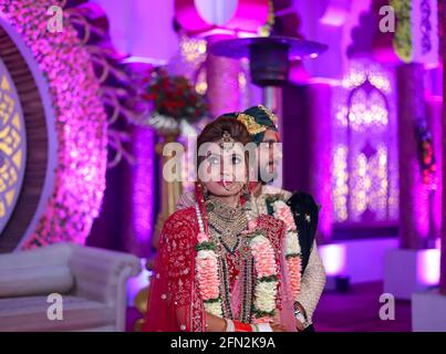 Wunderschöne atemberaubende indische Braut und Bräutigam tragen traditionell Kleid posieren auf ihrer Hochzeitszeremonie. Stockfoto