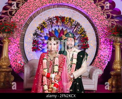 Wunderschöne atemberaubende indische Braut und Bräutigam tragen traditionell Kleid posieren auf ihrer Hochzeitszeremonie. Stockfoto