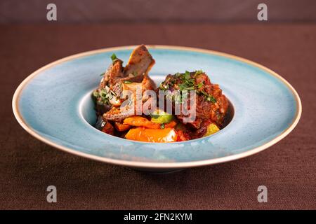 Roastbeef mit Kartoffeln auf einem blauen Teller. Stockfoto