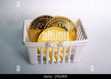 Bitcoins im Warenkorb auf grauem Hintergrund aus nächster Nähe Stockfoto