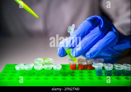 Wissenschaftler, der grüne chemische Lösung aus dem eppendorf-Röhrchen herausnimmt Ein weißer Hintergrund für die medizinische Chemie-Forschung Stockfoto