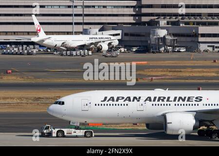 Eine Boeing 777-246 (er) von Japan Airlines (JAL) wird am Haneda International Airport abgeschleppt. Stockfoto
