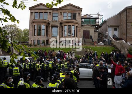 Glasgow, Großbritannien. Mai 2021. Eine Demonstration in der Kenmure Straße im Gebiet Pollokshields der Stadt, um gegen die Inhaftierung von zwei eingewanderten Männern durch Immigrationsgefangenenbeamte zu protestieren, wurde von einer starken Polizeipräsenz getroffen, als Demonstranten Straßen blockierten, die den Ausstieg des Einwanderungswagens verhinderten. Nach stundenlangen Verhandlungen wurden die Einwanderer kostenlos freigelassen. Foto: jeremy sutton-hibbert/Alamy Live News Stockfoto