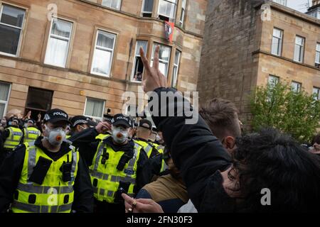 Glasgow, Großbritannien. Mai 2021. Eine Demonstration in der Kenmure Straße im Gebiet Pollokshields der Stadt, um gegen die Inhaftierung von zwei eingewanderten Männern durch Immigrationsgefangenenbeamte zu protestieren, wurde von einer starken Polizeipräsenz getroffen, als Demonstranten Straßen blockierten, die den Ausstieg des Einwanderungswagens verhinderten. Nach stundenlangen Verhandlungen wurden die Einwanderer kostenlos freigelassen. Foto: jeremy sutton-hibbert/Alamy Live News Stockfoto