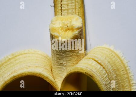 Halb verzehrtes Banana, teilweise geschält, reif gelb, gesunder nutrischer Snack. Stockfoto