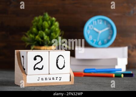 Januar. Januar 20 Holzwürfelkalender mit unscharfen Objekten auf dem Hintergrund. Stockfoto