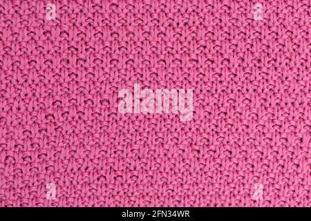 Rosa Strickstoff Perle Wollhintergrund. Die Struktur des Stoffes mit einer natürlichen Textur. Fabric-Hintergrund. Gestrickter wollener Hintergrund. Stockfoto