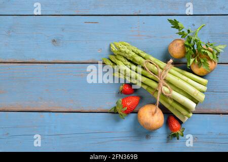 Frischer bayerischer grüner Spargel aus Schrobenhausen auf schäbig türkisfarbenem Platten mit Kopierplatz Stockfoto