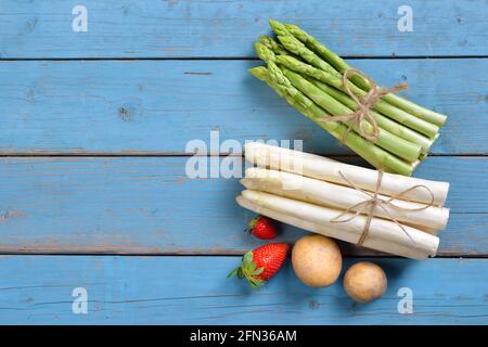 Frischer bayerischer weißer und grüner Spargel aus Schrobenhausen auf Shabby Türkisfarbene Bretter mit Kopierfläche Stockfoto