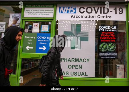 London, Großbritannien. Mai 2021. Die Menschen gehen an einer Apotheke in London vorbei, die Covid-19-Impfstoff anbietet. Quelle: Dinendra Haria/SOPA Images/ZUMA Wire/Alamy Live News Stockfoto