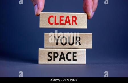 Löschen Sie das Leertaste-Symbol. Holzblöcke mit den Worten „Clear Your Space“. Schöne graue Hintergrund, Geschäftsmann Hand. Unternehmen, klären Sie Ihr Raumkonzept, Stockfoto