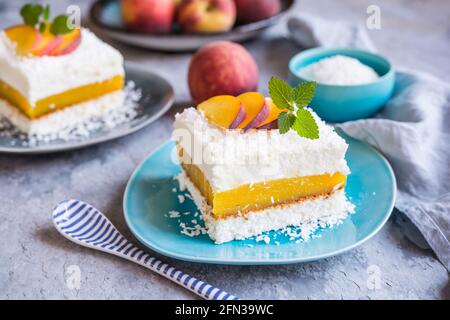 Erfrischendes Kokosnussdessert mit Pfirsichfüllung, gekrönt mit frischen Fruchtscheiben Stockfoto